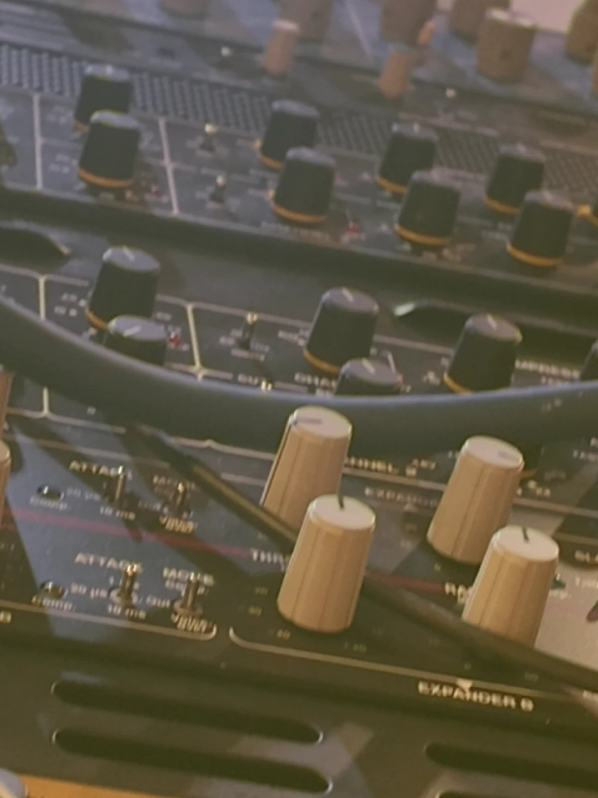 Close-up of a sound mixing console with knobs and labels.